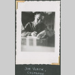 Man at desk writing (ddr-densho-434-48)