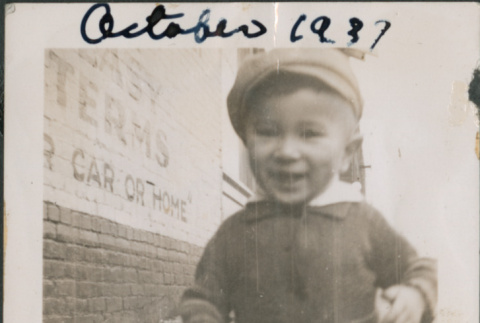 Toddler in sweater and hat walking on street (ddr-densho-483-701)