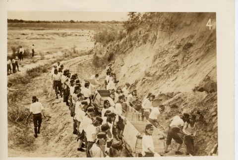 Men working on a railroad and soldiers walking across a bridge (ddr-njpa-6-112)