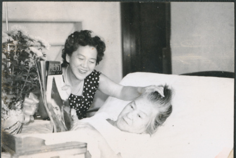 Agnes Sakura sitting by Hideko Kondo laying in bed (ddr-densho-523-331)