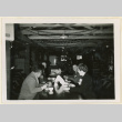 Diners in a mess hall decorated for Christmas (ddr-densho-37-1299)