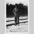 [Man in military uniform standing on railroad tracks] (ddr-csujad-1-27)