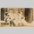 Two men and a woman with two small children seated outside building (ddr-densho-426-1899)