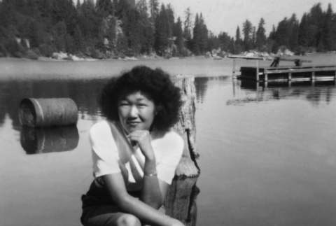 June Kitagawa sitting on a rock near the lake (ddr-densho-336-3)