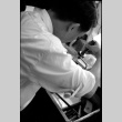 Man working with small saw, possibly a jeweler (ddr-densho-426-2409)