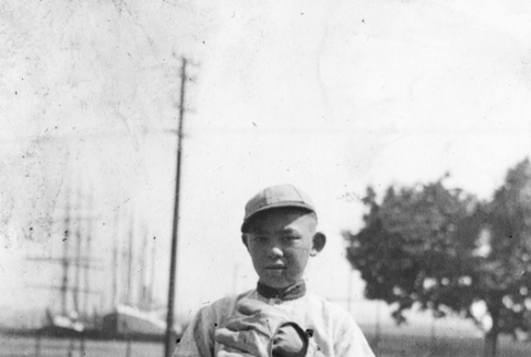 Boy in baseball uniform standing in field (ddr-ajah-5-80)