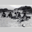 Six men relaxing on the beach, two in uniform (ddr-densho-474-244)