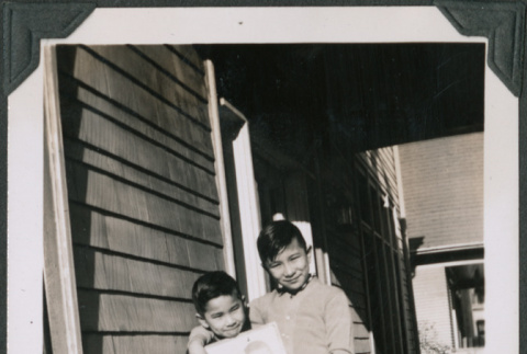 Photo of Paul and Kenji Ima holding a portrait (ddr-densho-483-1165)
