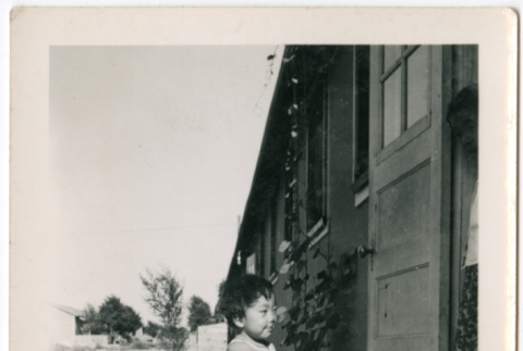 Girl pointing to woman in doorway of barracks (ddr-densho-329-1343)