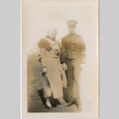 Tomoye (Nozawa) Takahashi standing with man in uniform (ddr-densho-426-1580)