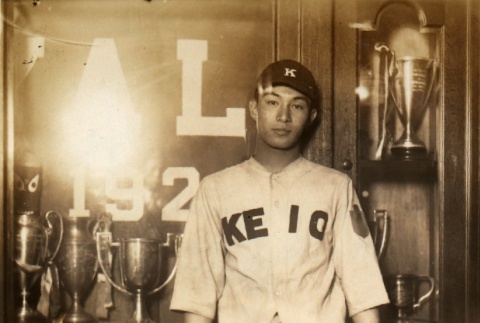 Keio University baseball player posing with trophies (ddr-njpa-4-1531)