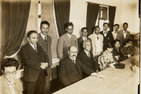A group standing and sitting at a table (ddr-njpa-1-2216)