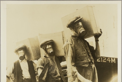 Men in gas masks carrying boxes (ddr-njpa-13-1525)