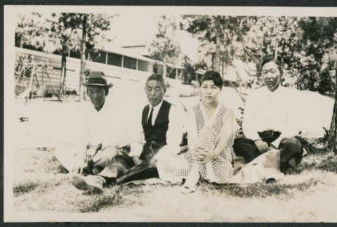 3 men and 1 woman sitting in a yard (ddr-densho-378-830)