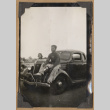 Man seated on a car fender (ddr-densho-542-141)