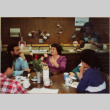 Woman telling story to others seated at table (ddr-densho-426-1277)