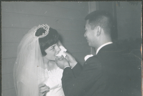 groom feeding bride a piece of cake (ddr-densho-523-348)