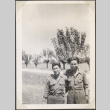 Two men in uniform by row of trees (ddr-densho-466-26)