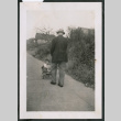 Photo of a man pushing a child in a wagon (ddr-densho-483-811)