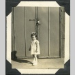 Young girl standing outside of barracks (ddr-manz-4-233)