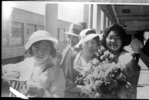 Family on board ship.  Likely Tomoye (Nozawa) Takahashi with flowers on right (ddr-densho-426-1849)