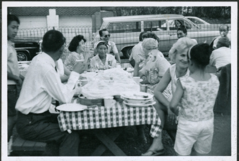 Group sitting at picnic table eating (ddr-densho-293-177)