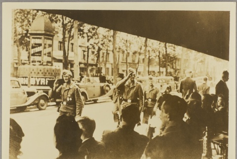 Passing soldiers saluting civilians at a cafe (ddr-njpa-13-1349)