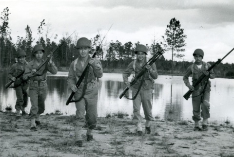 Soldiers holding rifles on a riverbank (ddr-densho-22-465)