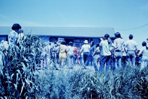 Pilgrims visiting the ruins of a barracks at Tule Lake (ddr-densho-294-43)