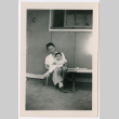 Woman holding toddler girl sitting outside barracks (ddr-densho-329-1277)