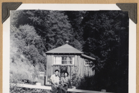 Couple seated on a barrier (ddr-densho-542-352)