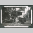 Photo of a family of three in front of a jeep with a trailer (ddr-densho-483-381)