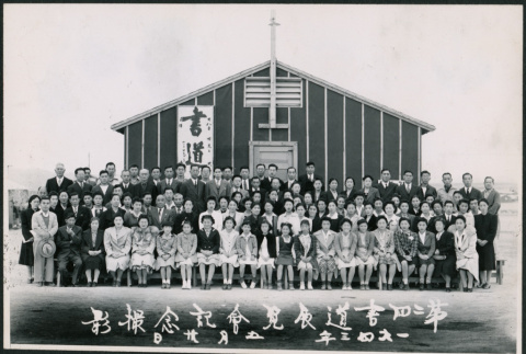 Large group of men and women in front of a camp building (ddr-densho-362-29)