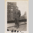 Man standing on roof with building in background (ddr-densho-466-428)