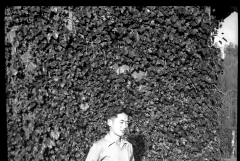Man standing in front of ivy-covered wall (ddr-densho-475-84)