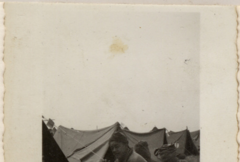 Man sitting on ground near tents (ddr-densho-466-370)