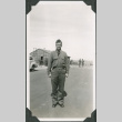 Man in uniform standing in road with barracks in background (ddr-ajah-2-84)