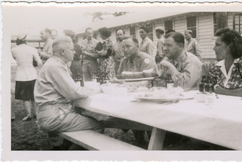 Four people seated at a picnic table (ddr-densho-434-509)