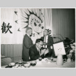 Three men at speakers table with banner in background (ddr-ajah-2-15)