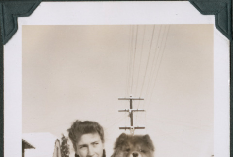 Photo of a woman holding a dog in snow (ddr-densho-483-1278)