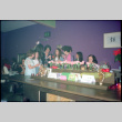 Group standing around piano, singing (ddr-densho-426-605)