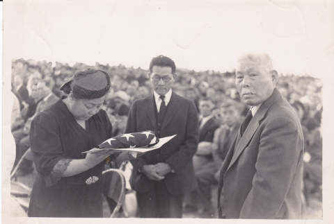 Fred Suyekichi and Akino Kinoshita receiving a flag (ddr-densho-348-12)