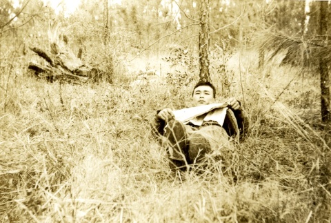 Soldier laying in a field (ddr-densho-22-225)