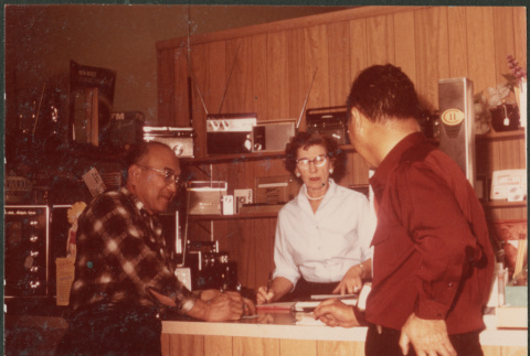 Chester Sakura Sr. with woman and man at electronics store (ddr-densho-523-449)
