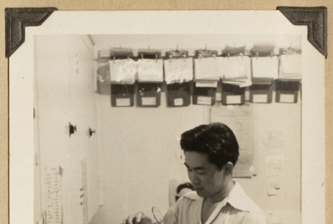 Gary Kikawa working at a counter (ddr-densho-542-521)
