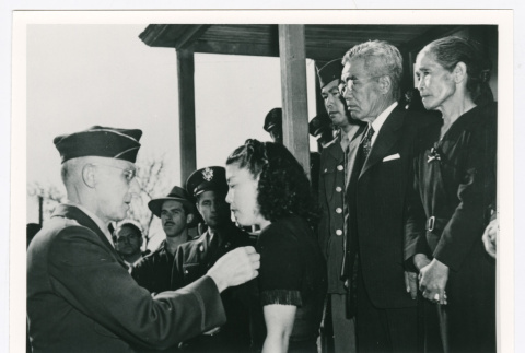 Woman receiving pin from officer (ddr-densho-1007-308)