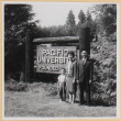Couple and child standing by sign for Pacific University (ddr-densho-522-66)
