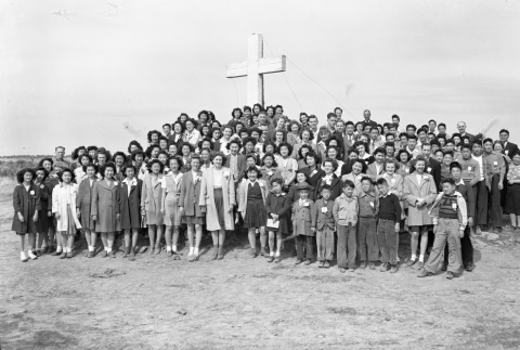 Group gathered in front of an outdoor cross in camp (ddr-fom-1-99)