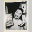 Woman holding a photograph and purple heart (ddr-densho-37-1946)