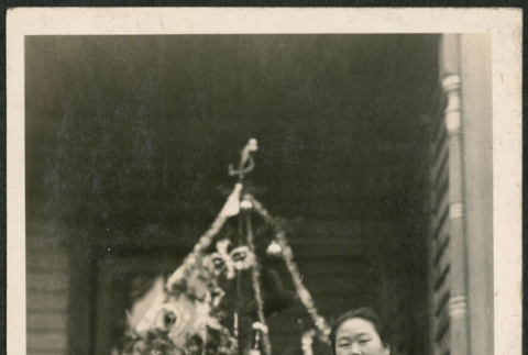 Woman and girl with dolls standing in from of Christmas tree (ddr-densho-293-66)